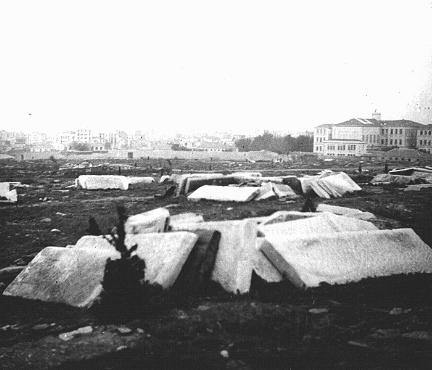 Broken Jewish gravestones lying in an open field after destruction