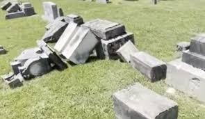 Toppled Jewish gravestones lying in the grass