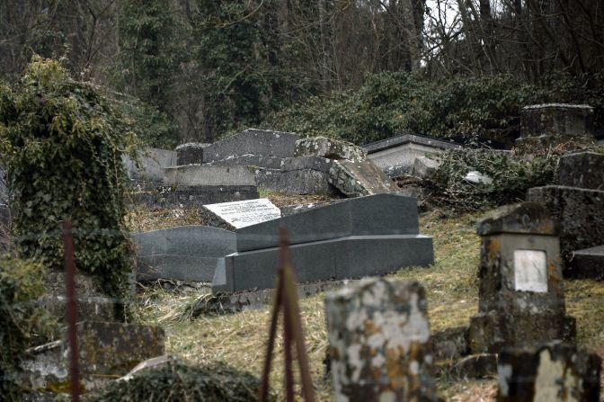 An overturned grave in a French Jewish cemetery overrun with brush