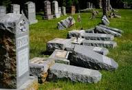 A row of Jewish gravestones pushed over together in a cemetery attack